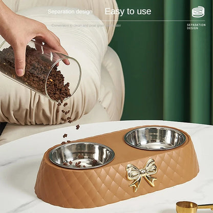 Pet feeding station with two bowls and a decorative bow, being filled with food.